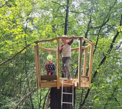 Children smiling while climbing the 'crows nest'