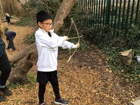 Child practicing with their hand-made bow and arrow  