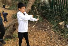 Child practicing with their hand-made bow and arrow  