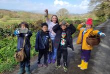 ChChildren smilling with their collected finds from foraging in woodland and meadow